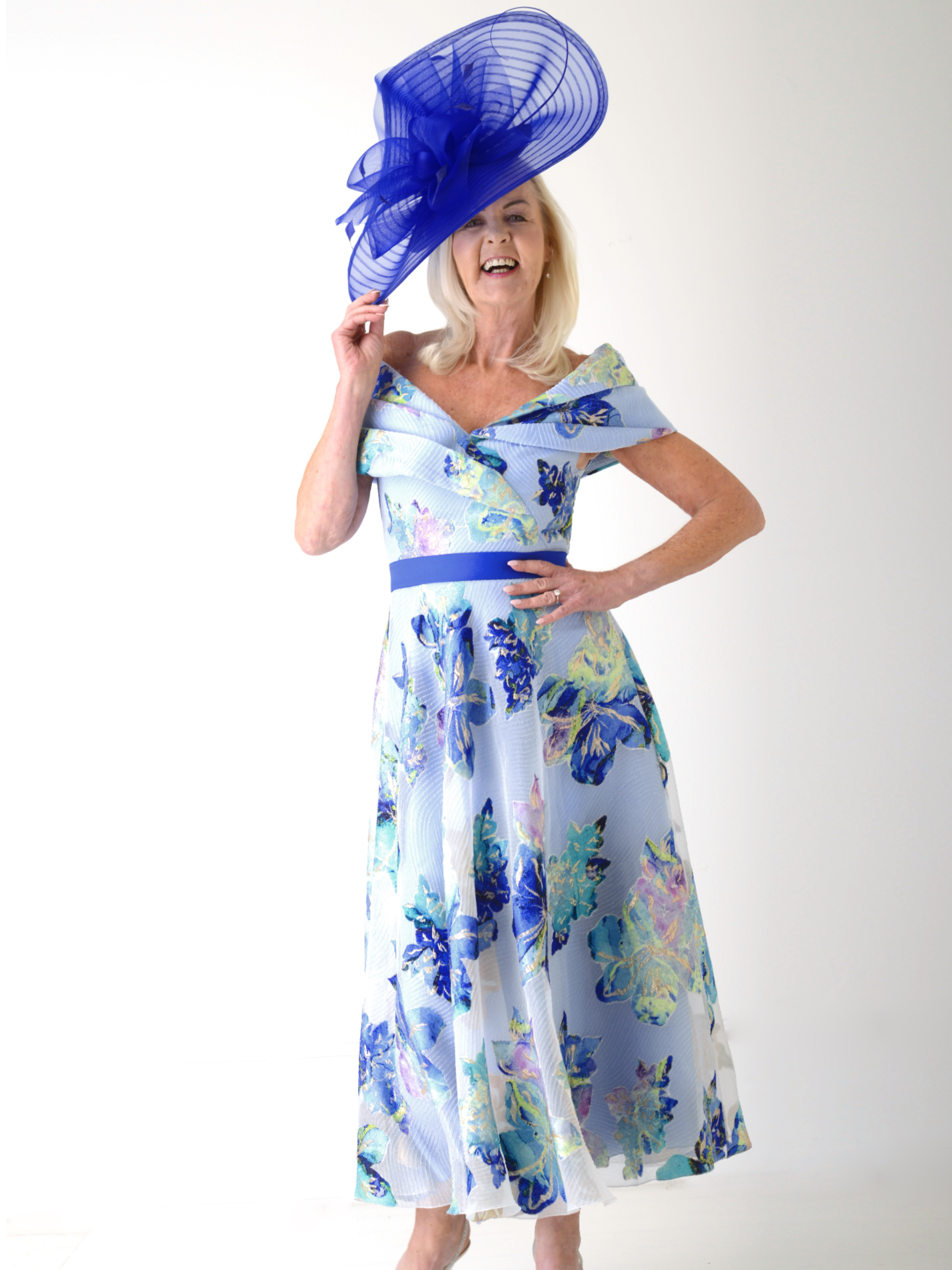 Gabriela Sanchez 5714 Unico / Azul Dress off-the-shoulder floral occasion dress with fitted bodice, blue waistband and flowing A-line skirt.