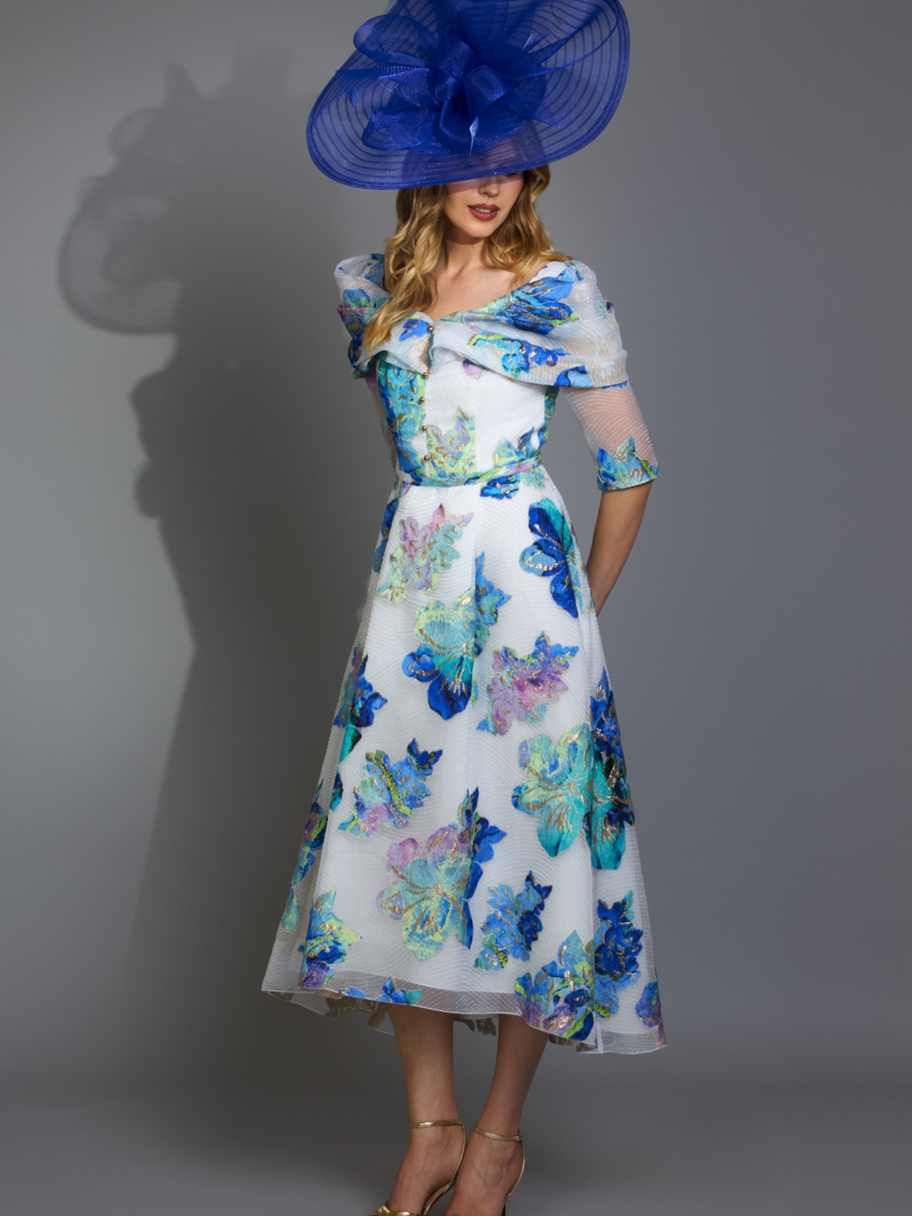Gabriela Sanchez 5715 Unico / Crudo Dress off-the-shoulder floral occasion dress with crossover neckline, sheer sleeves and flowing A-line skirt.