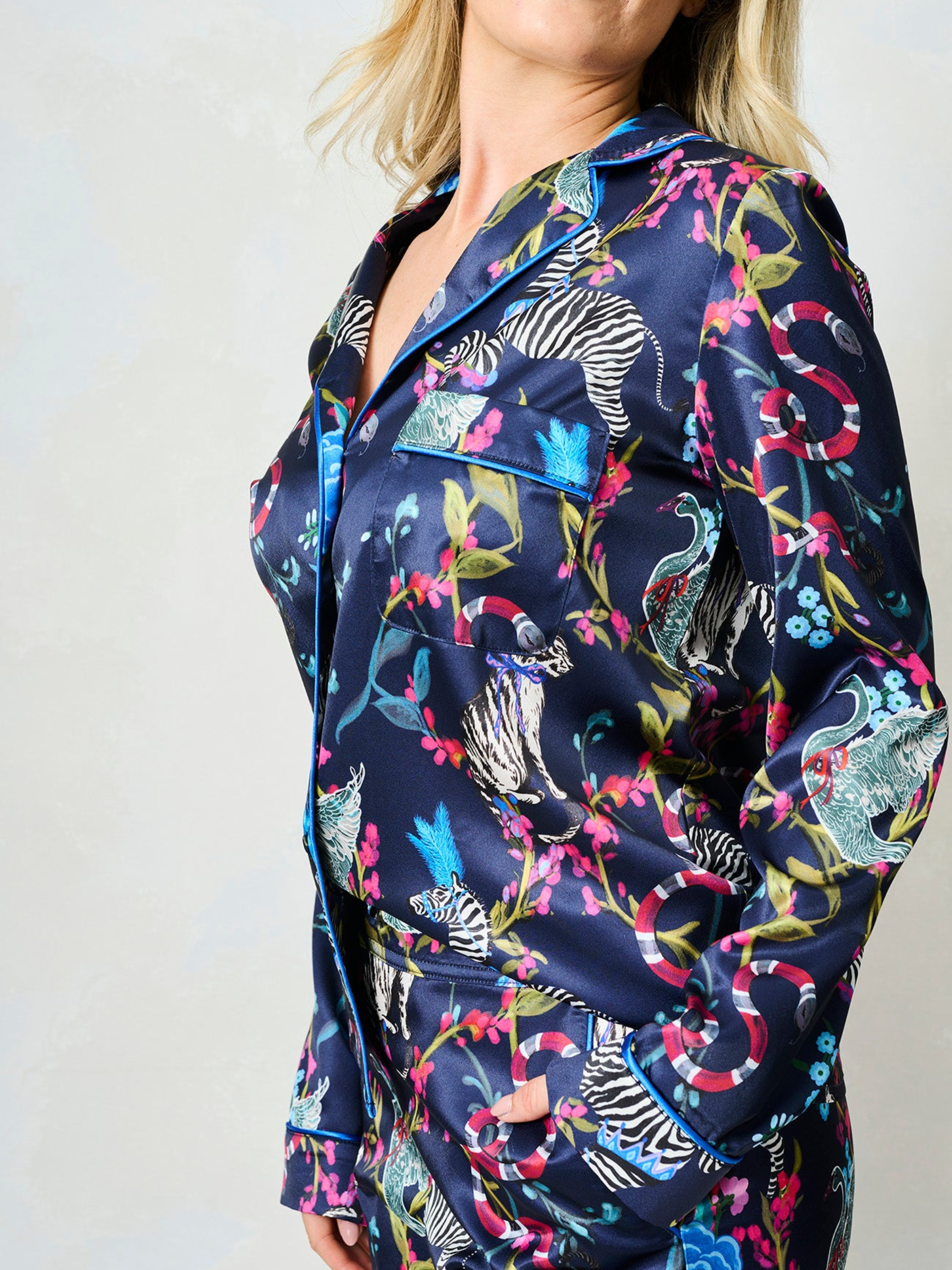Hope & Ivy SUZANNE Zebra Pyjamas – women’s satin pyjama set featuring hand-painted zebra and floral print, blue piping, button-up shirt and matching trousers. Ideal for lounging, gifting or travel.