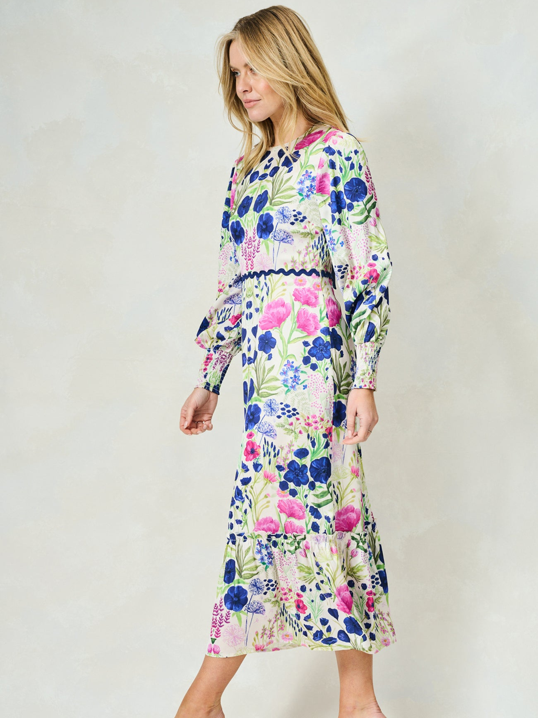 Hope & Ivy Caroline White Floral Maxi Dress – sustainable women’s satin floral print dress with blouson sleeves, frilled hem and tie-back detail. Ideal for weddings, garden parties and summer occasions.