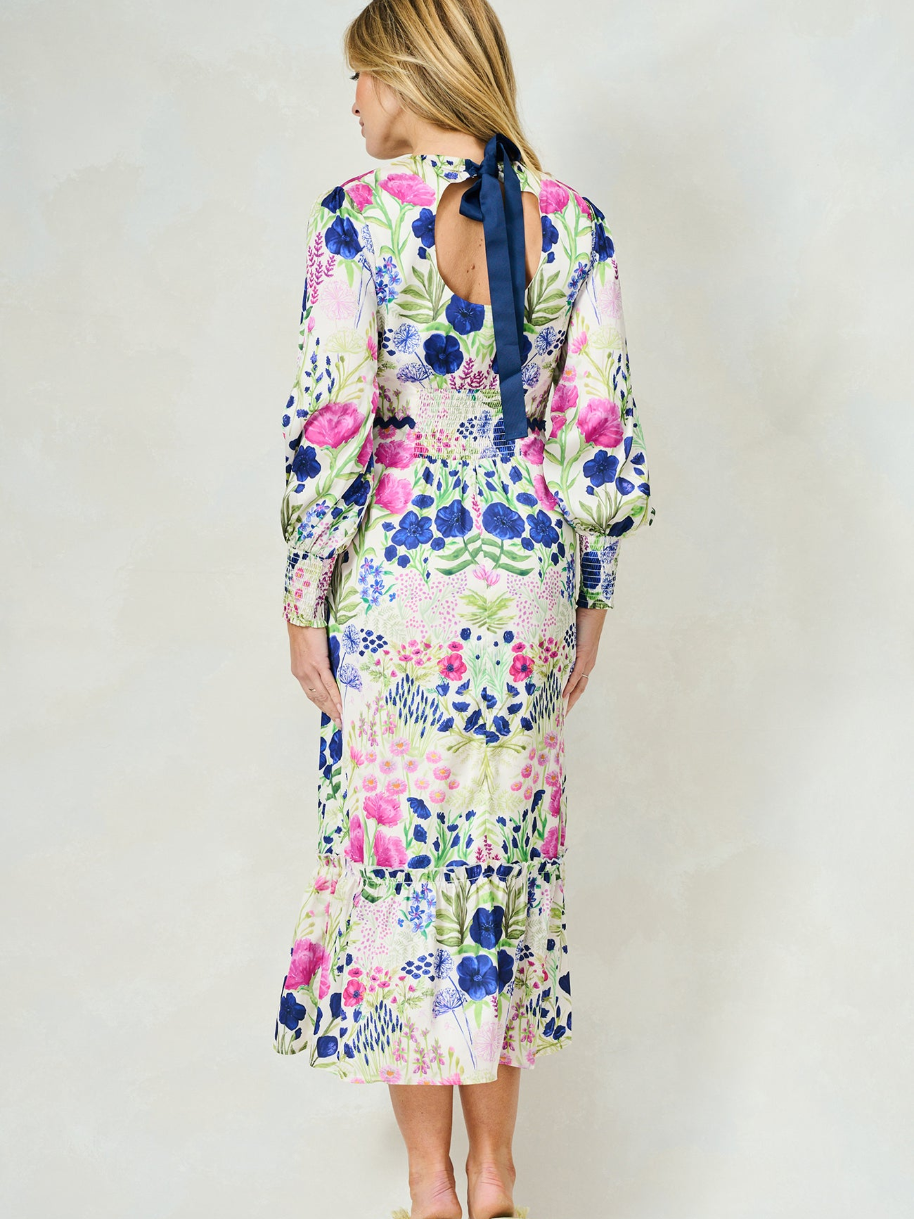 Hope & Ivy Caroline White Floral Maxi Dress – sustainable women’s satin floral print dress with blouson sleeves, frilled hem and tie-back detail. Ideal for weddings, garden parties and summer occasions.