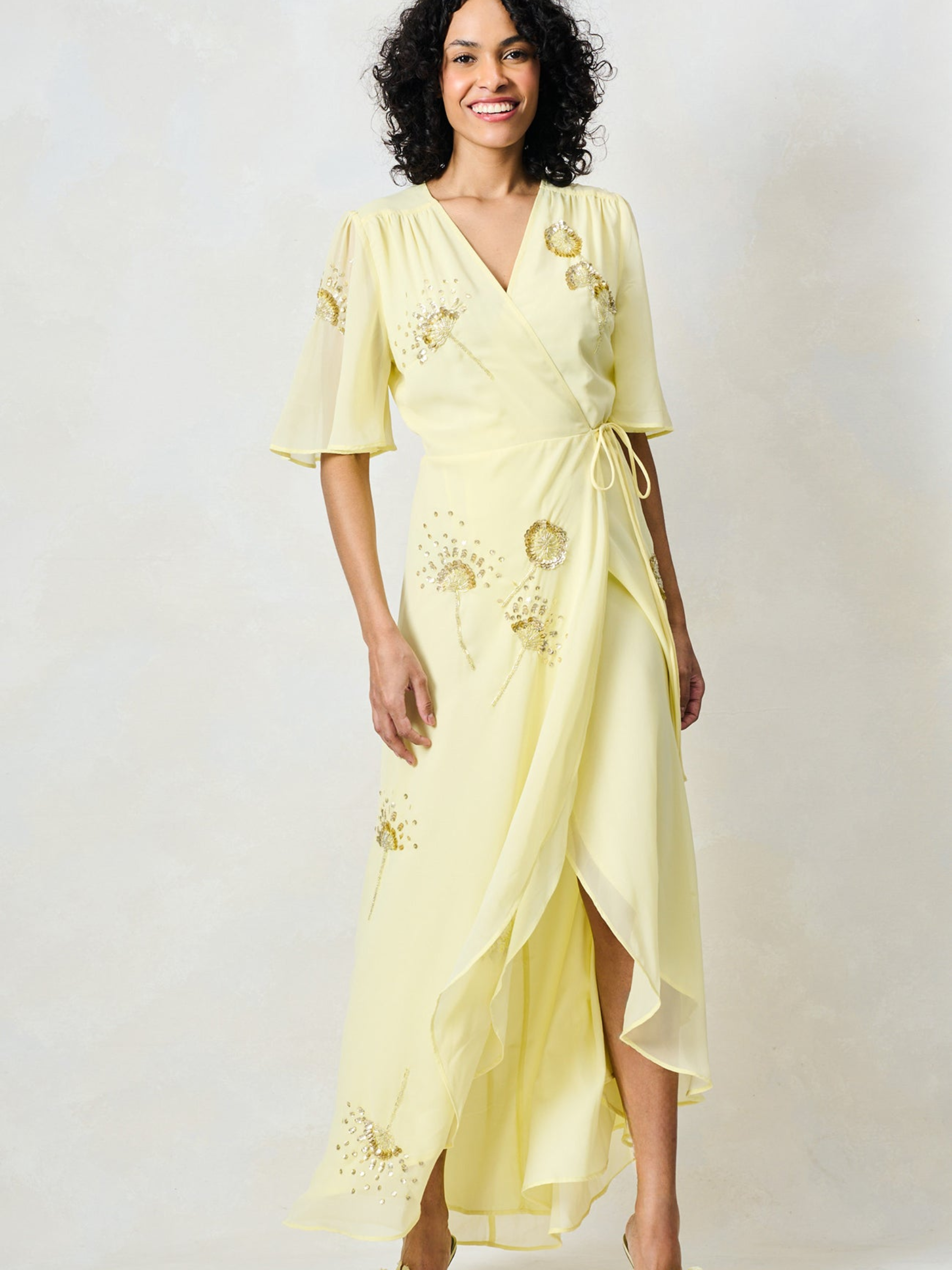 Hope & Ivy Joy Yellow Dress with wrap silhouette, flutter sleeves, embellished detailing and flowing maxi skirt.