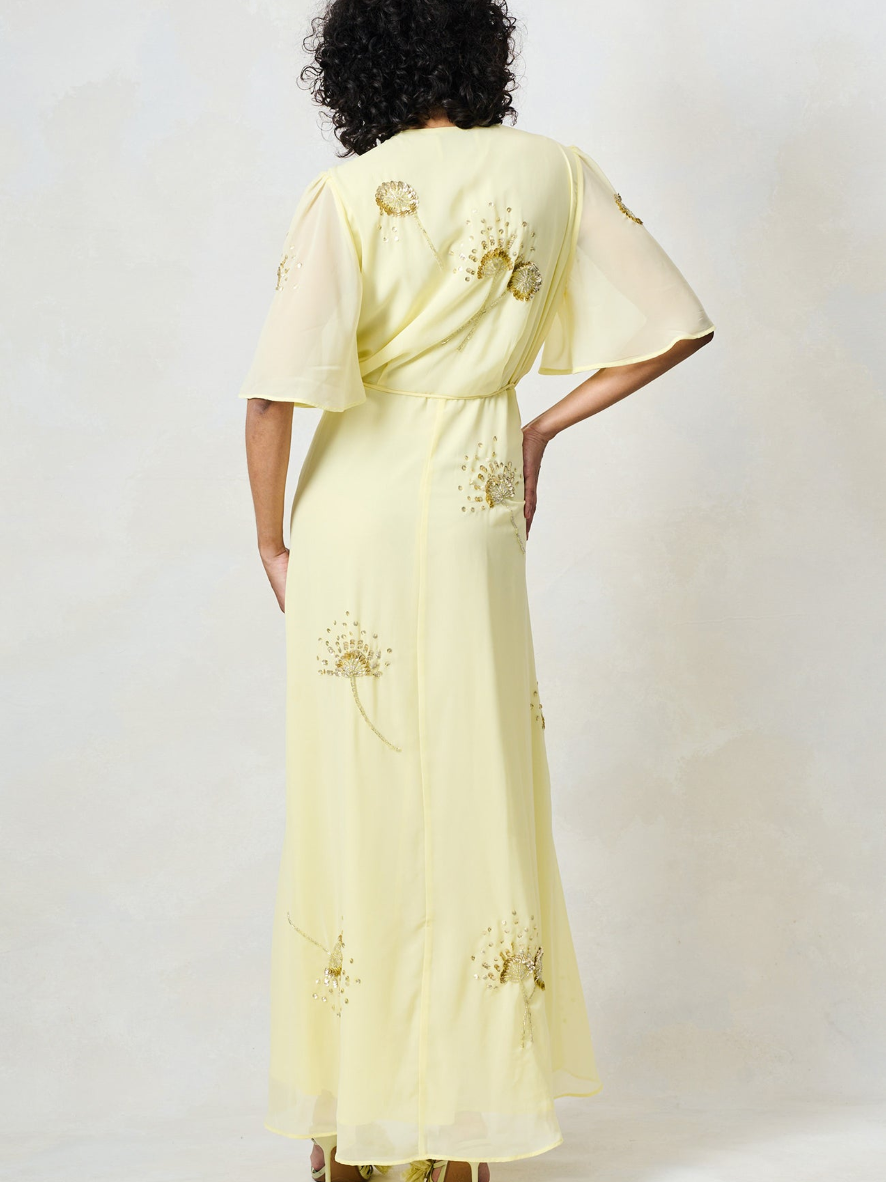 Hope & Ivy Joy Yellow Dress with wrap silhouette, flutter sleeves, embellished detailing and flowing maxi skirt.