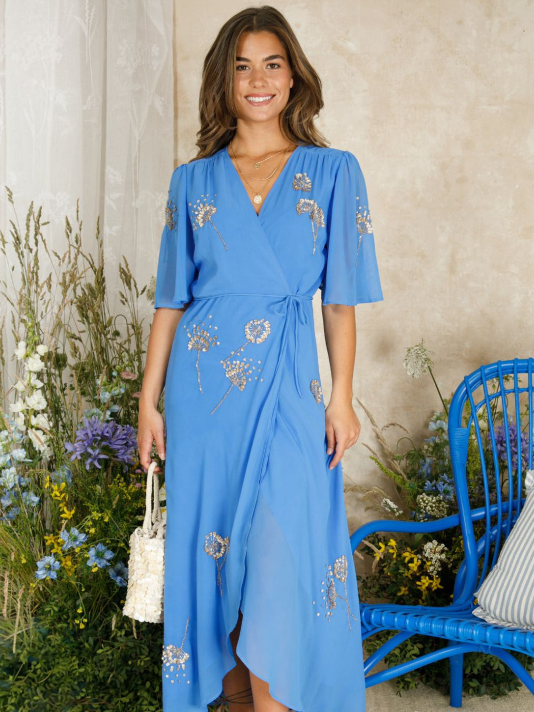 Hope & Ivy Mallory Blue Embellished Wrap Dress – elegant blue embellished maxi wrap dress with silver and gold detailing, flutter sleeves, and tie waist. Perfect for weddings and evening occasions.