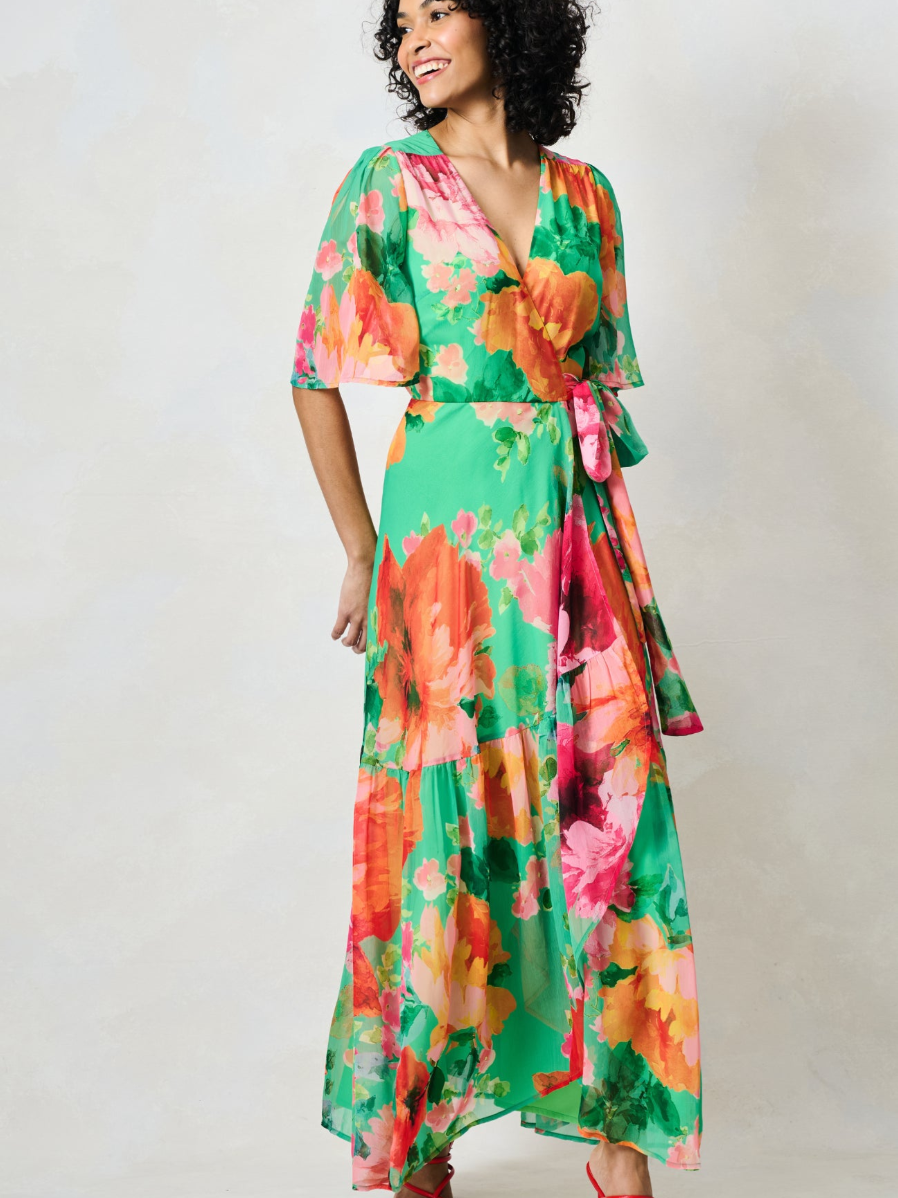 Hope & Ivy Samantha Green Floral Dress with wrap silhouette, flutter sleeves, tie waist and flowing maxi skirt.