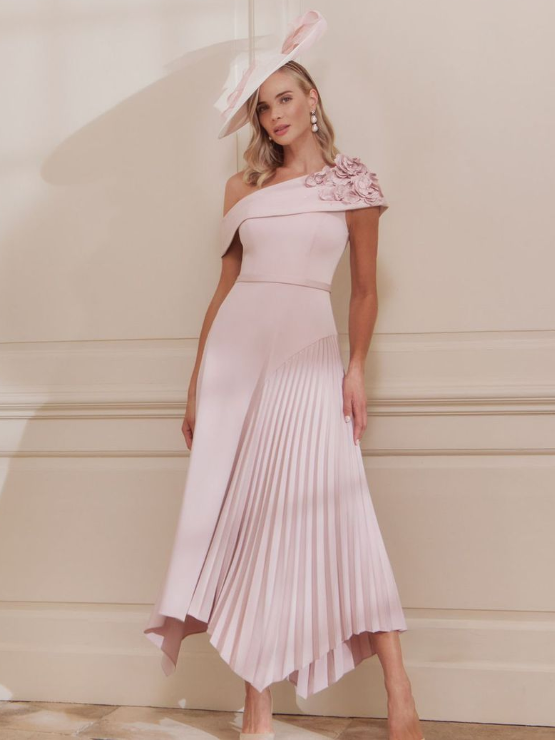 John Charles 29362A Petal Dress with one-shoulder neckline, 3D floral appliqués and pleated asymmetric midi skirt – a romantic petal-pink occasion dress ideal for weddings and elegant events.
