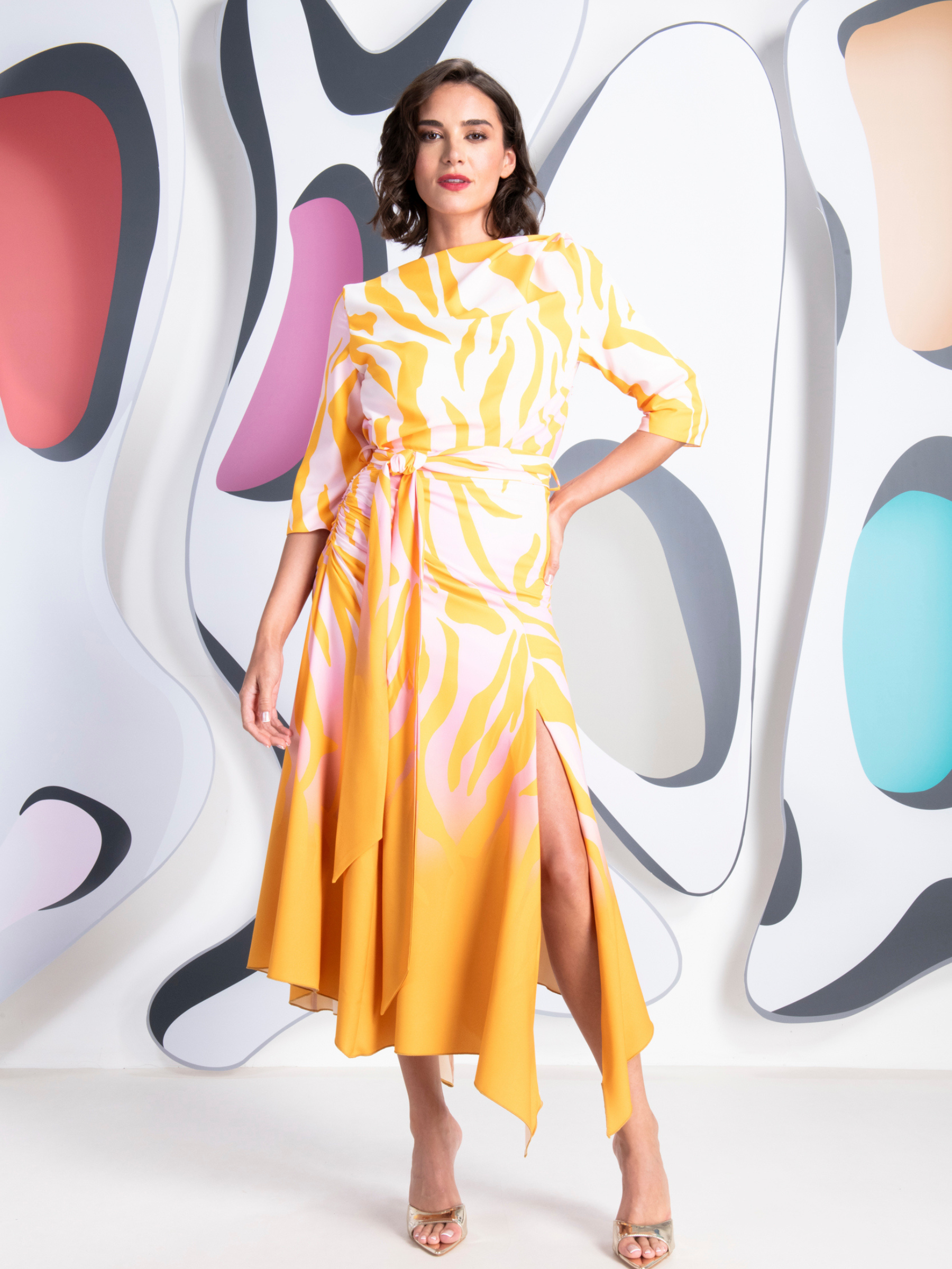 Kevan Jon Dotty Pink/Yellow Sleeve Drape Dress in zebra ombré fabric with high neckline, ruched tie waist and asymmetric draped skirt with side split.