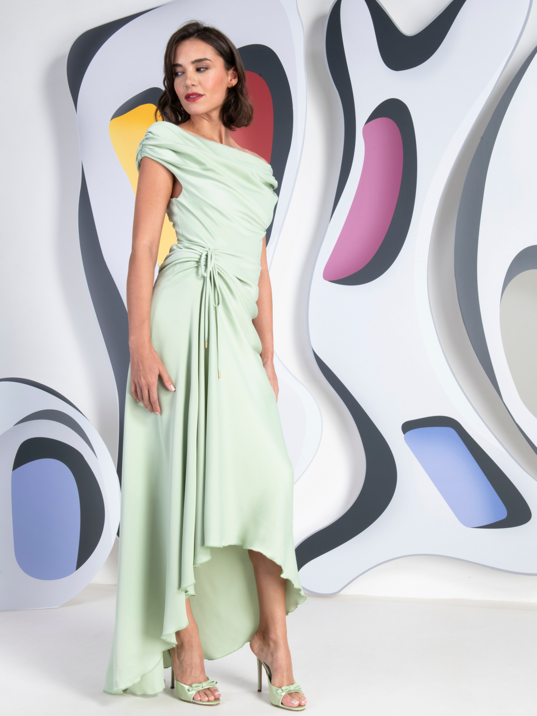 Kevan Jon Eugenia Bardot Asym Mint Dress in satin crepe with bardot draped neckline, ruched drawstring waist and asymmetric waterfall skirt.