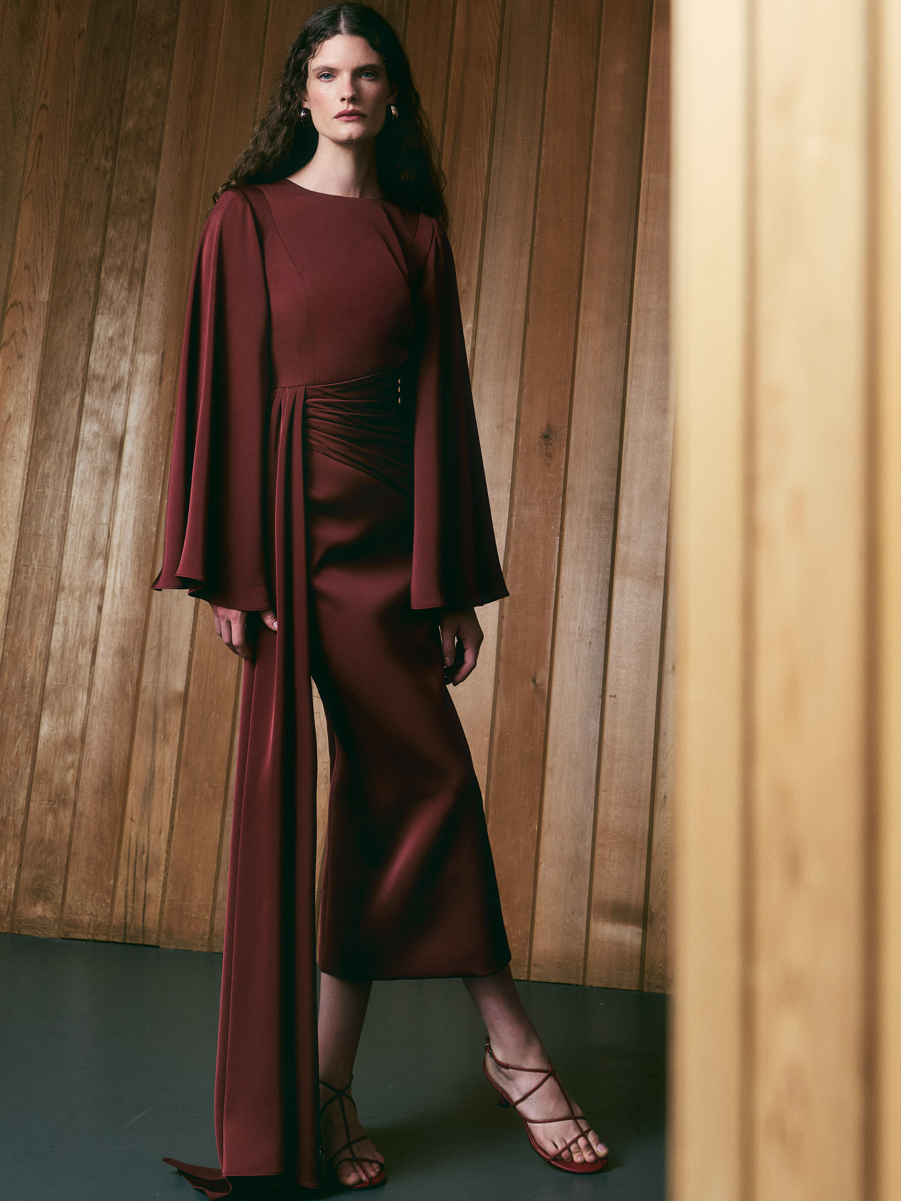Maisonel ME3198B Brick Dress with round neckline, flowing cape-style sleeves, gathered waist and draped side detail