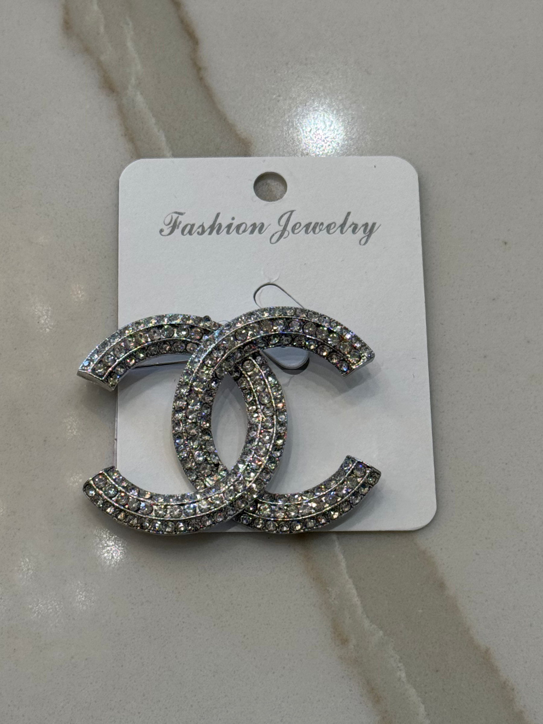 Nouvelle CC Brooch Silver – luxury women’s crystal brooch with double C design, silver-tone finish and sparkling rhinestones. Perfect statement accessory for blazers, scarves and evening wear.