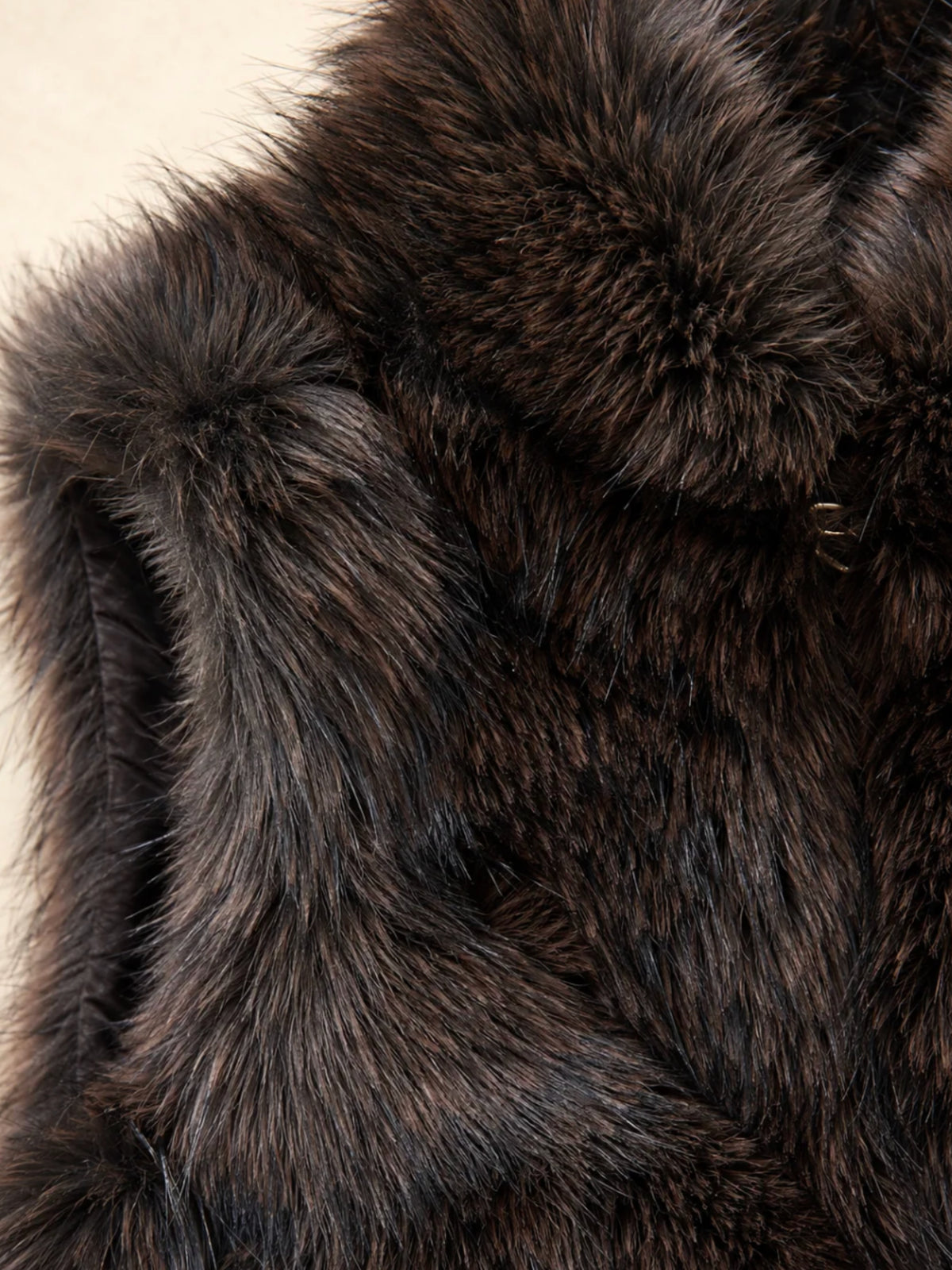 QBAW26 CW Darcy Faux Fur Short Gilet with soft textured finish, sleeveless design, high neckline and pockets.