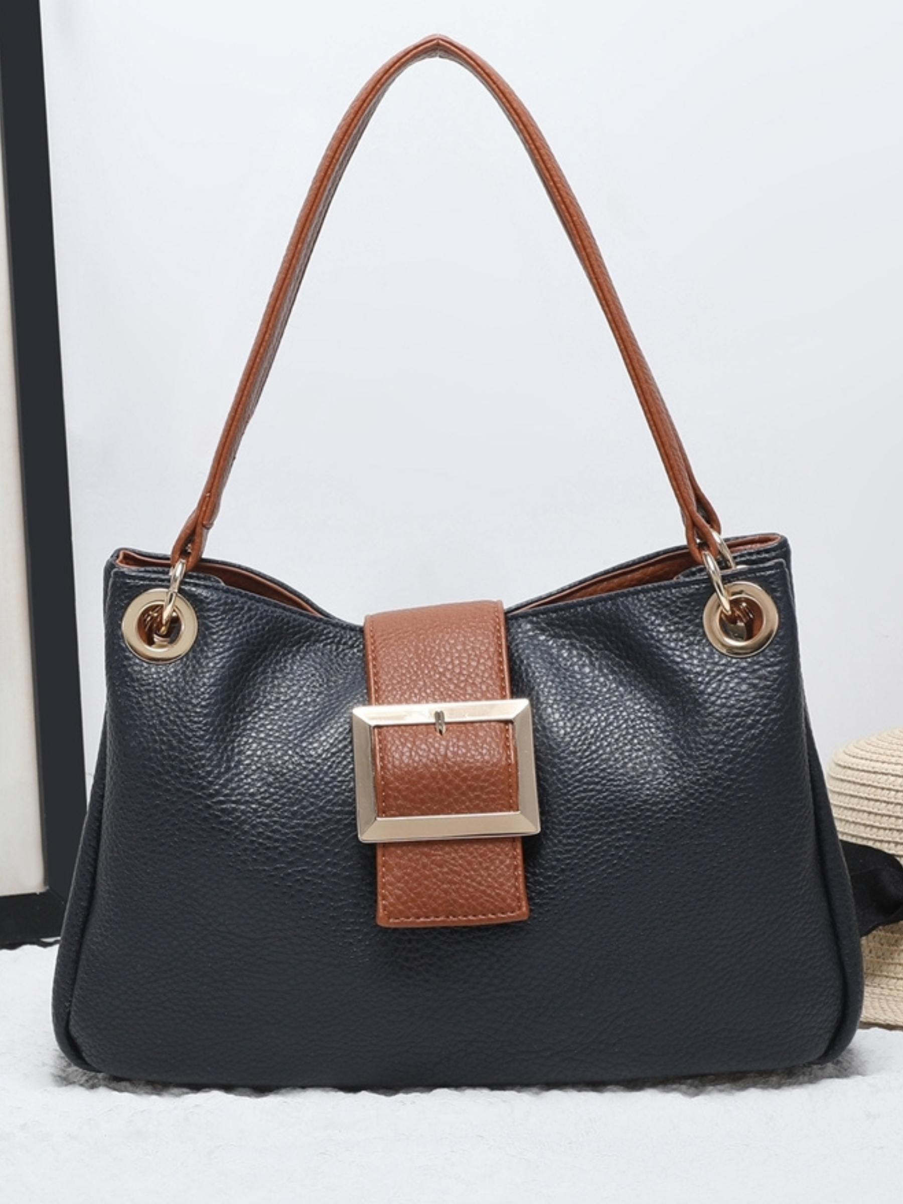QB Milan 25444 Jane Navy Bag featuring a structured shape, gold-tone hardware and buckle detail with tan handles. Elegant and practical, also available in Wine and Black.