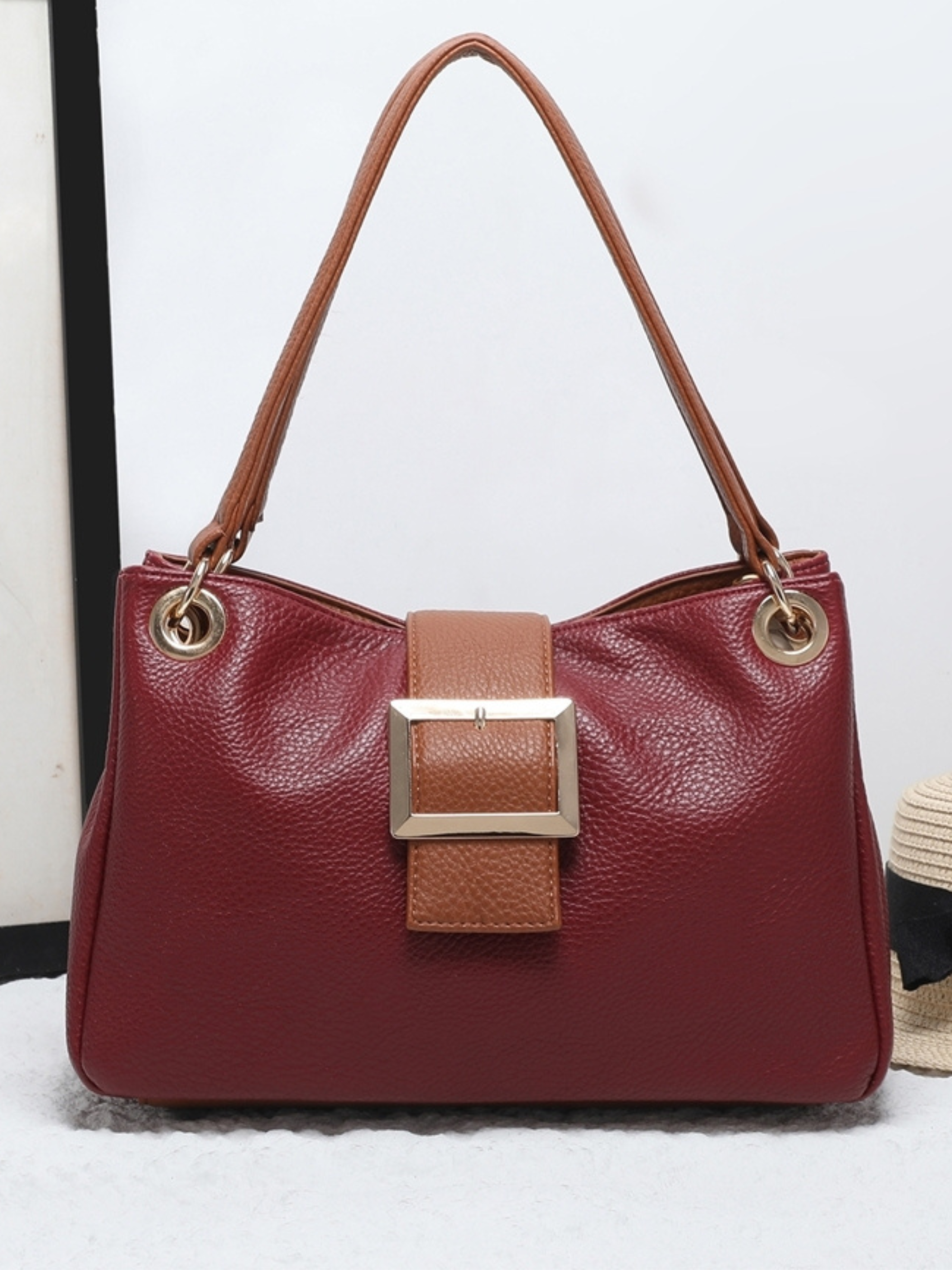 QB Milan 25444 Jane Wine Bag featuring a structured design with tan handles, gold-tone hardware and an oversized buckle. A stylish and practical handbag perfect for elevating everyday or evening outfits.