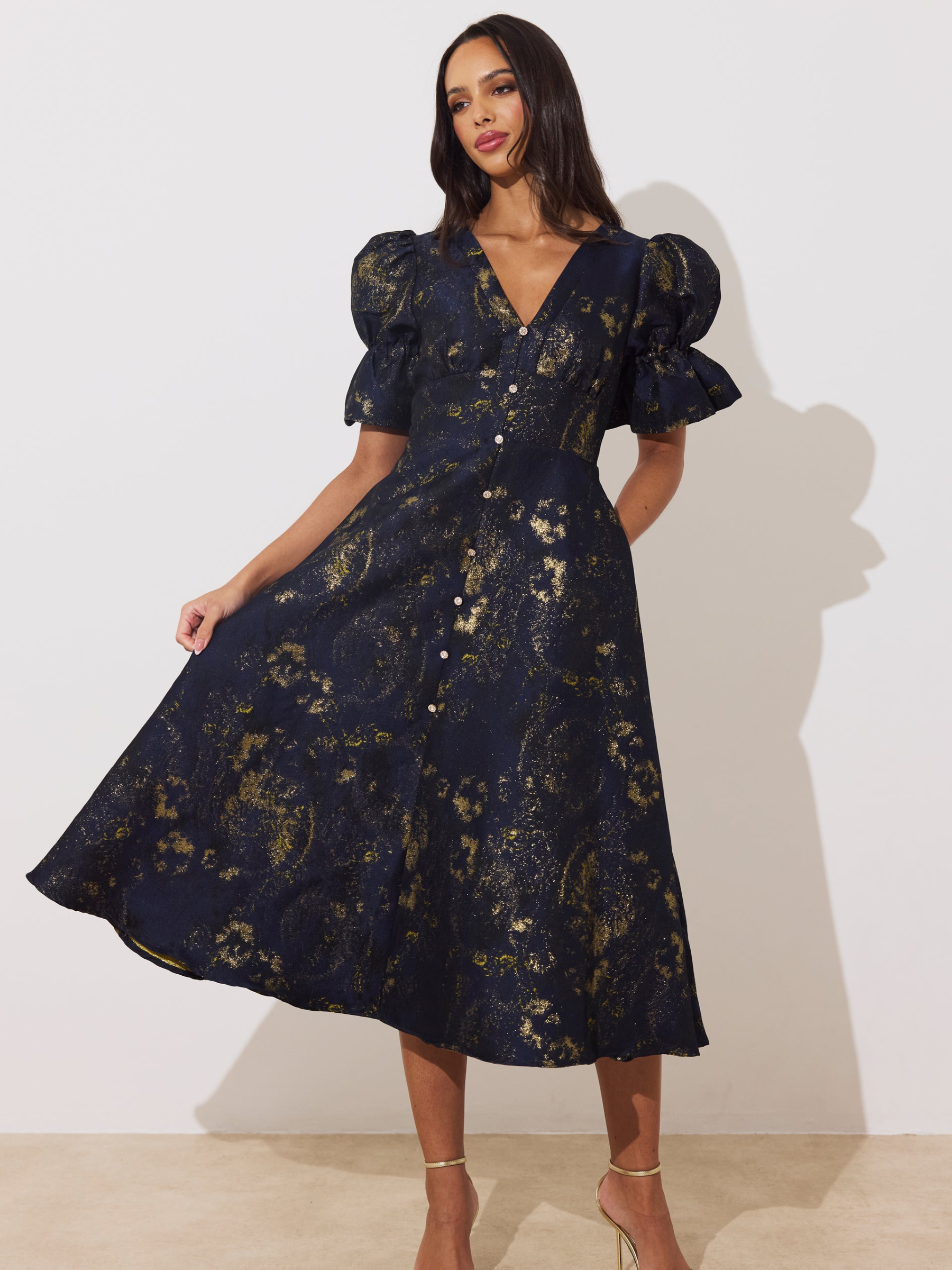 The 8th Sign Callie Metallic Skater Dress with V-neckline, puff sleeves, button-front detail and flared skirt.