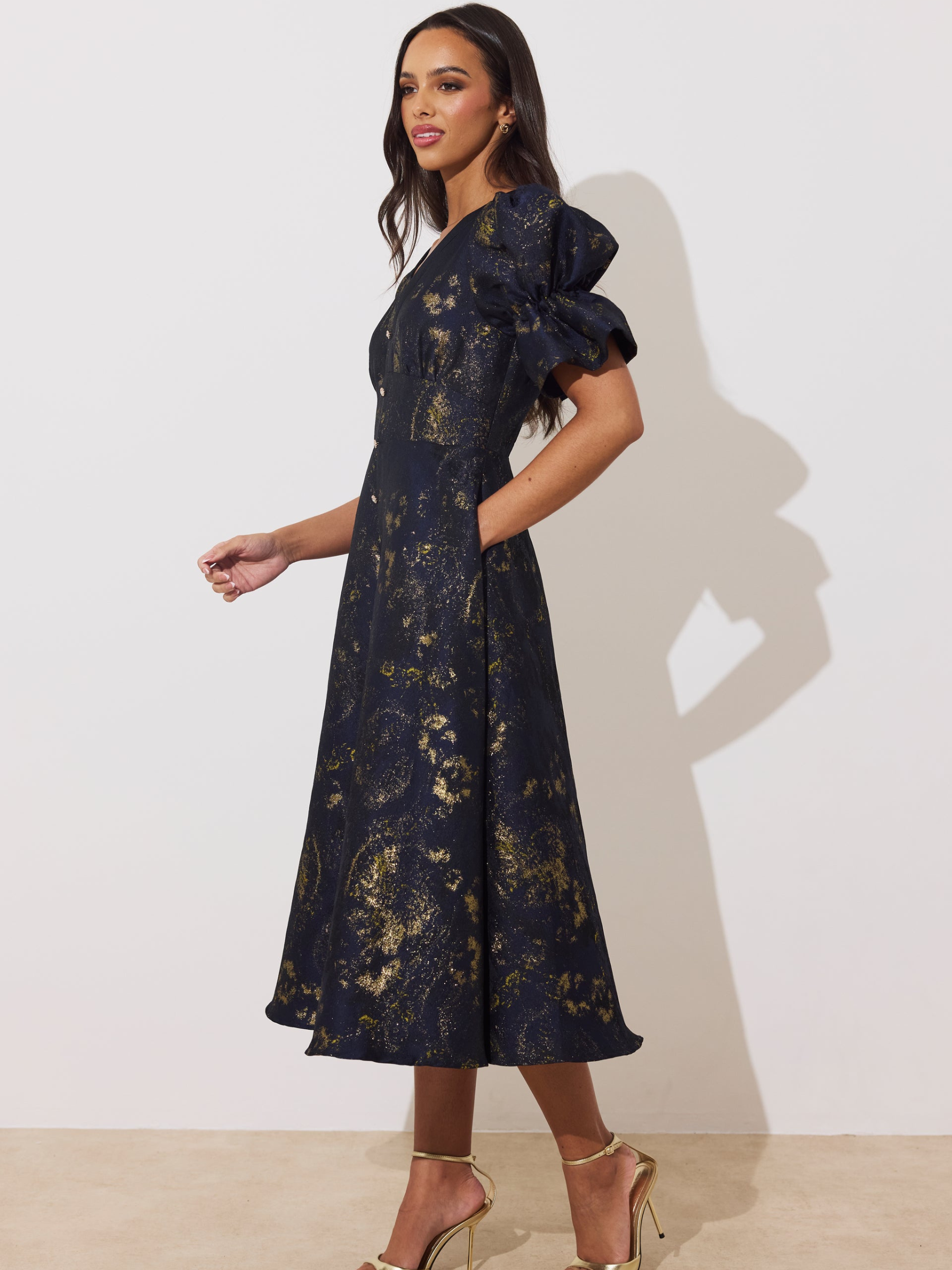 The 8th Sign Callie Metallic Skater Dress with V-neckline, puff sleeves, button-front detail and flared skirt.
