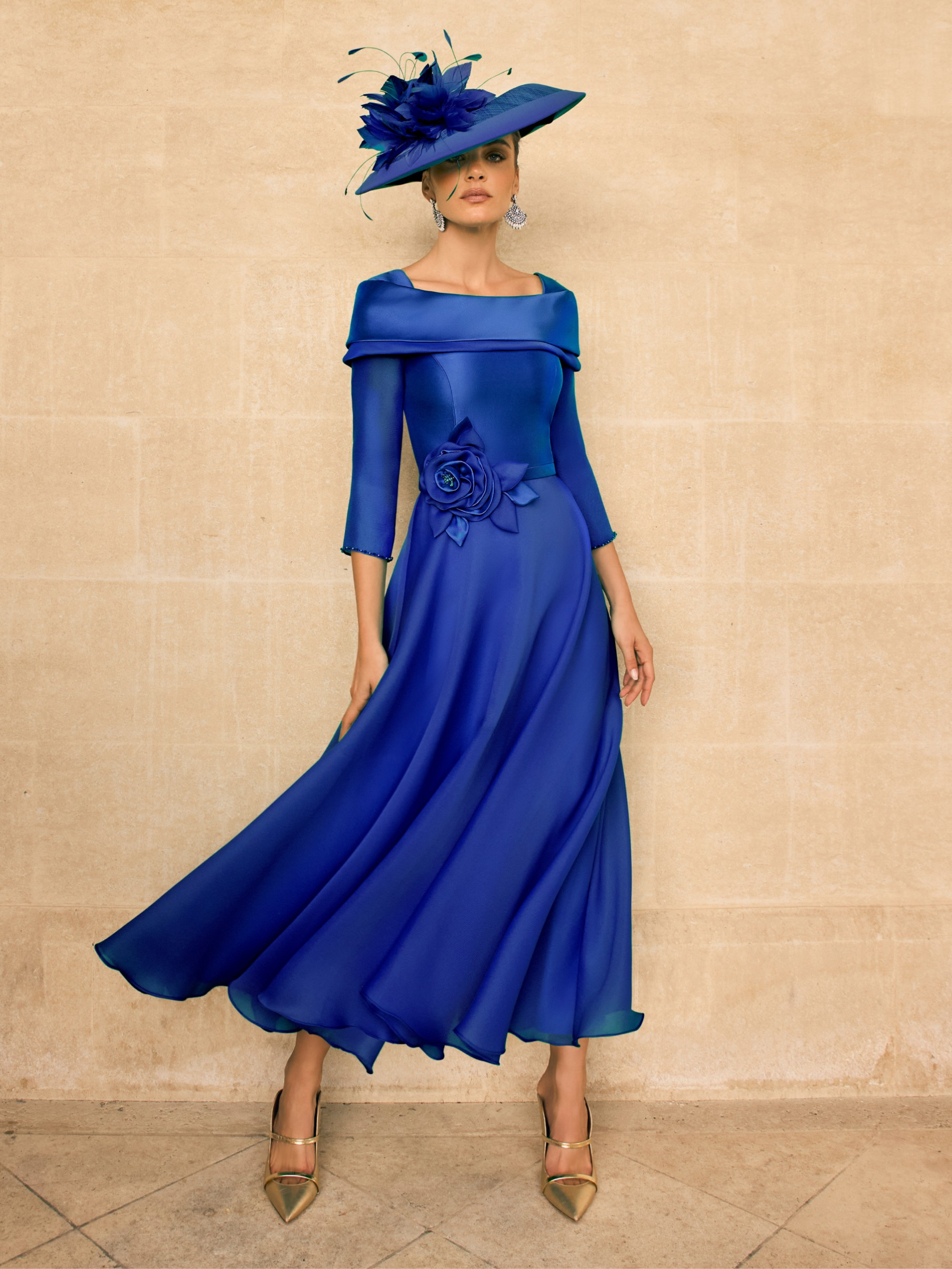 Veni Infantino 992720B Royal Blue Dress with straight collar, beaded trim, floral waist detail and flared A-line midi skirt in mikado and organza. Elegant royal blue occasion dress.