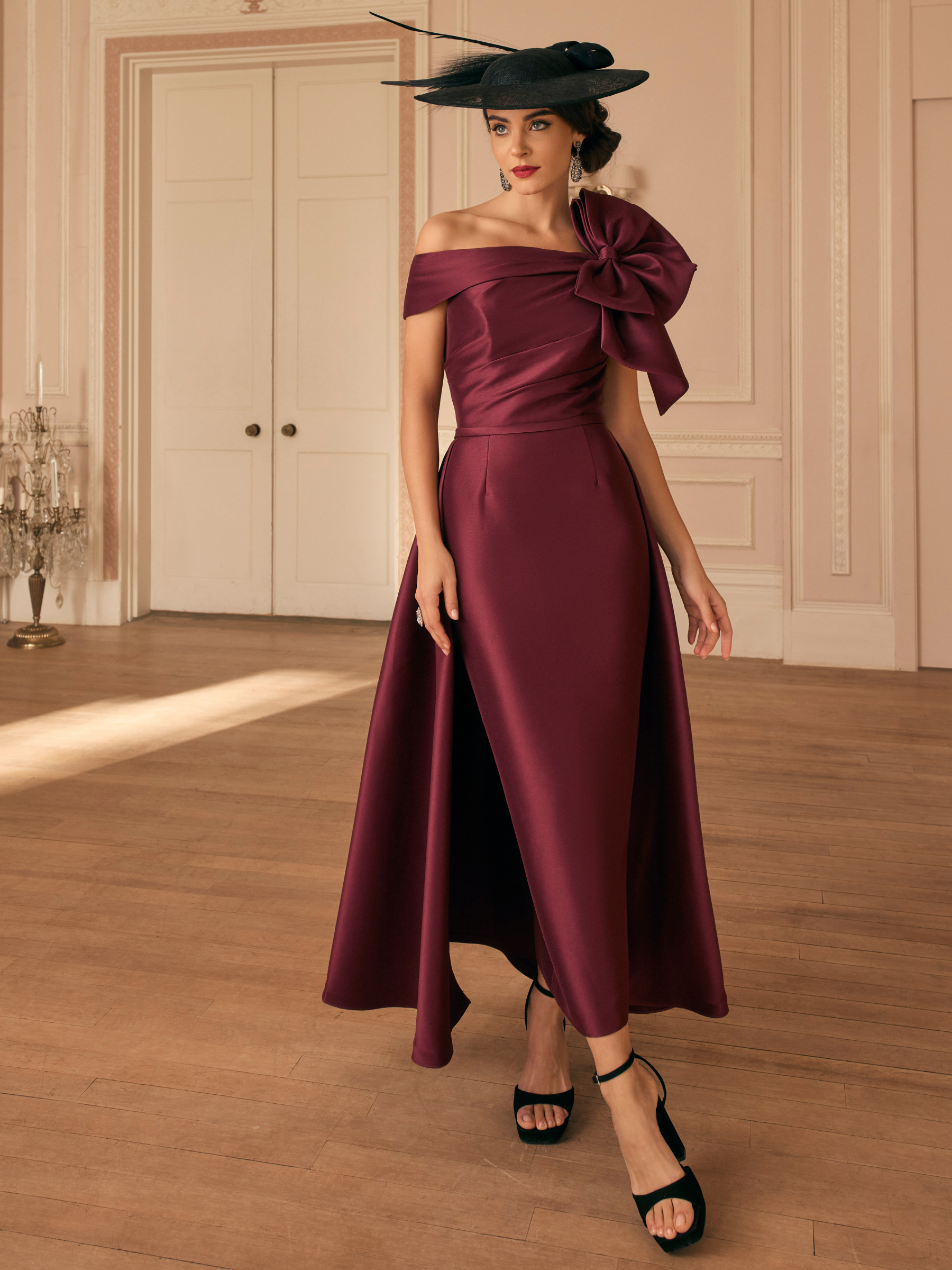 Veni Infantino 992820 Maroon Dress with off-the-shoulder neckline, oversized bow detail and high-low fit and flare silhouette