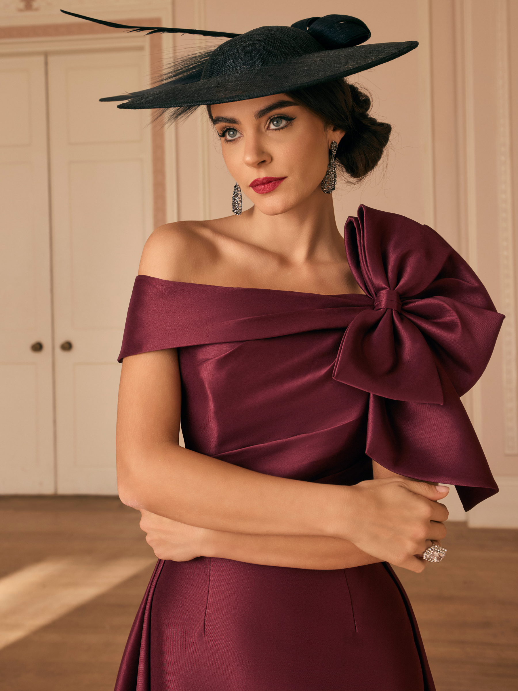 Veni Infantino 992820 Maroon Dress with off-the-shoulder neckline, oversized bow detail and high-low fit and flare silhouette