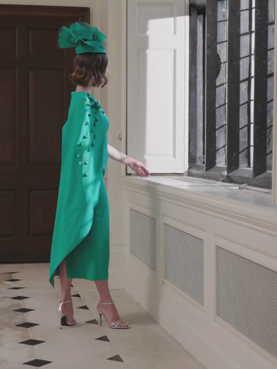 John Charles 29303 Peacock Dress with asymmetric floral-appliqué cape, sculpted crepe bodice and fitted midi pencil skirt — a sophisticated peacock-blue occasion dress perfect for weddings and formal events.