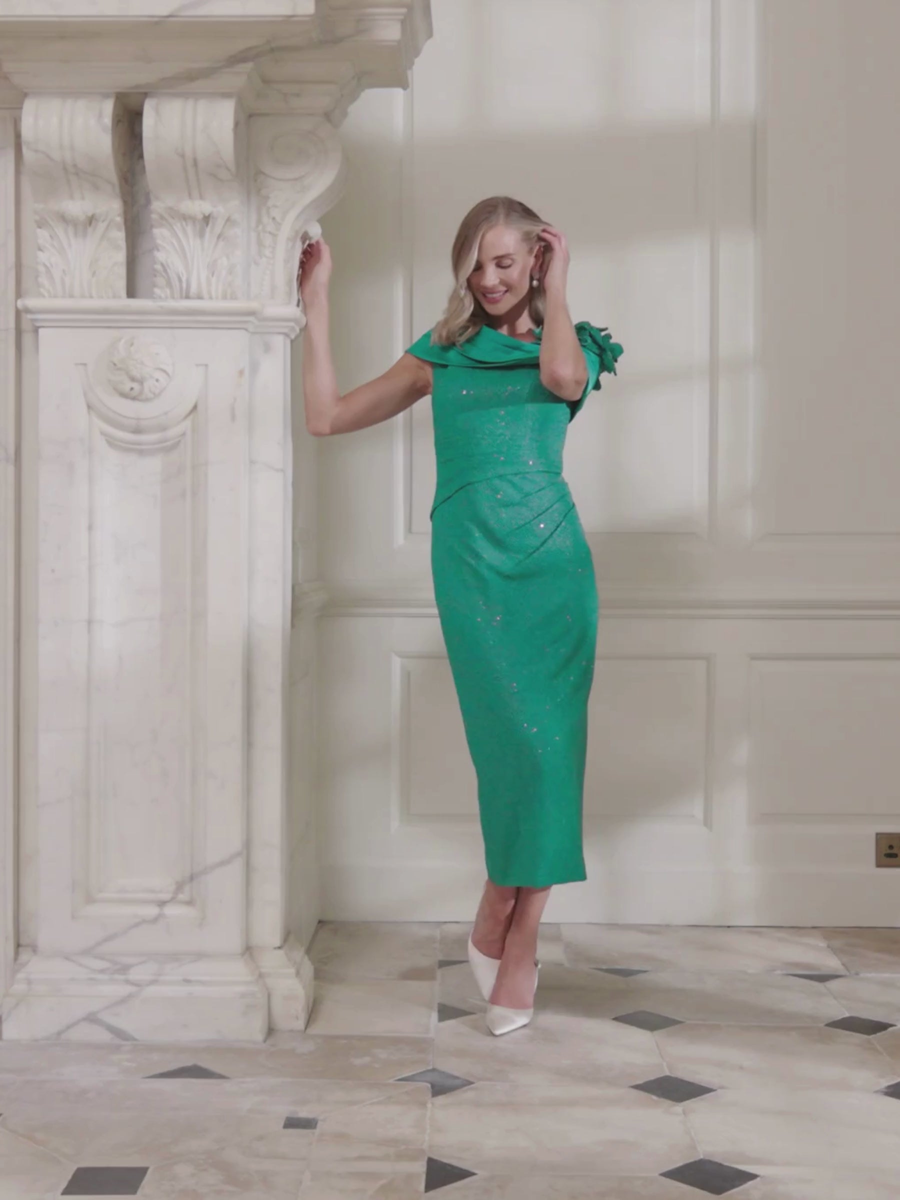 John Charles 29337A Peacock Dress with asymmetric bardot collar, sparkle stretch fabric, straight midi skirt and floral shoulder detailing.