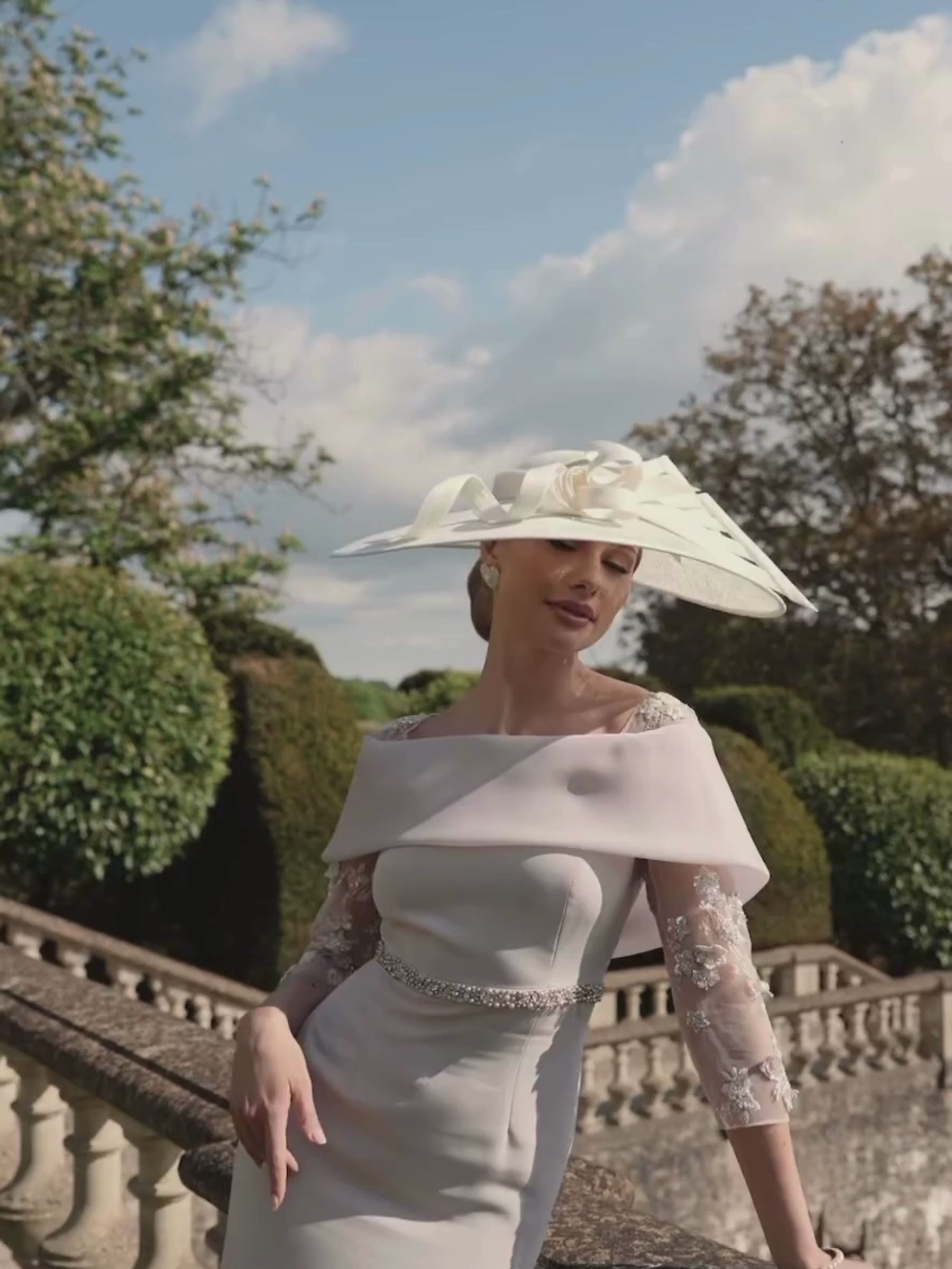 Veni Infantino 992746 Taupe crepe, organza and beaded tulle dress with fold over neckline, sheer embellished sleeves and sleek column silhouette. Elegant Mother of the Bride/Groom outfit for weddings and special occasions.