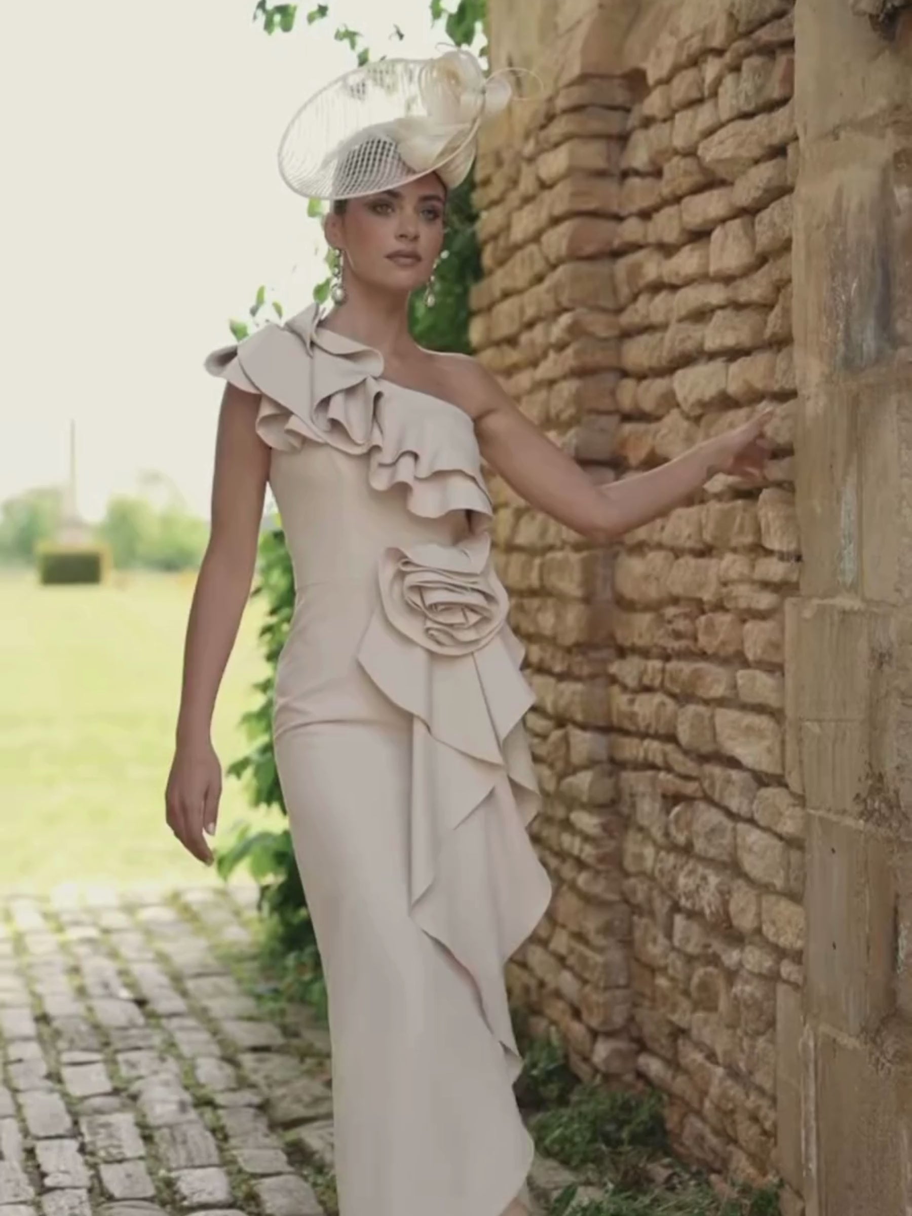 Veni Infantino 992737 Almond Dress in crepe with one-shoulder ruffle detailing, floral waist appliqué and flowing midi skirt. Elegant occasion dress for weddings and special events.