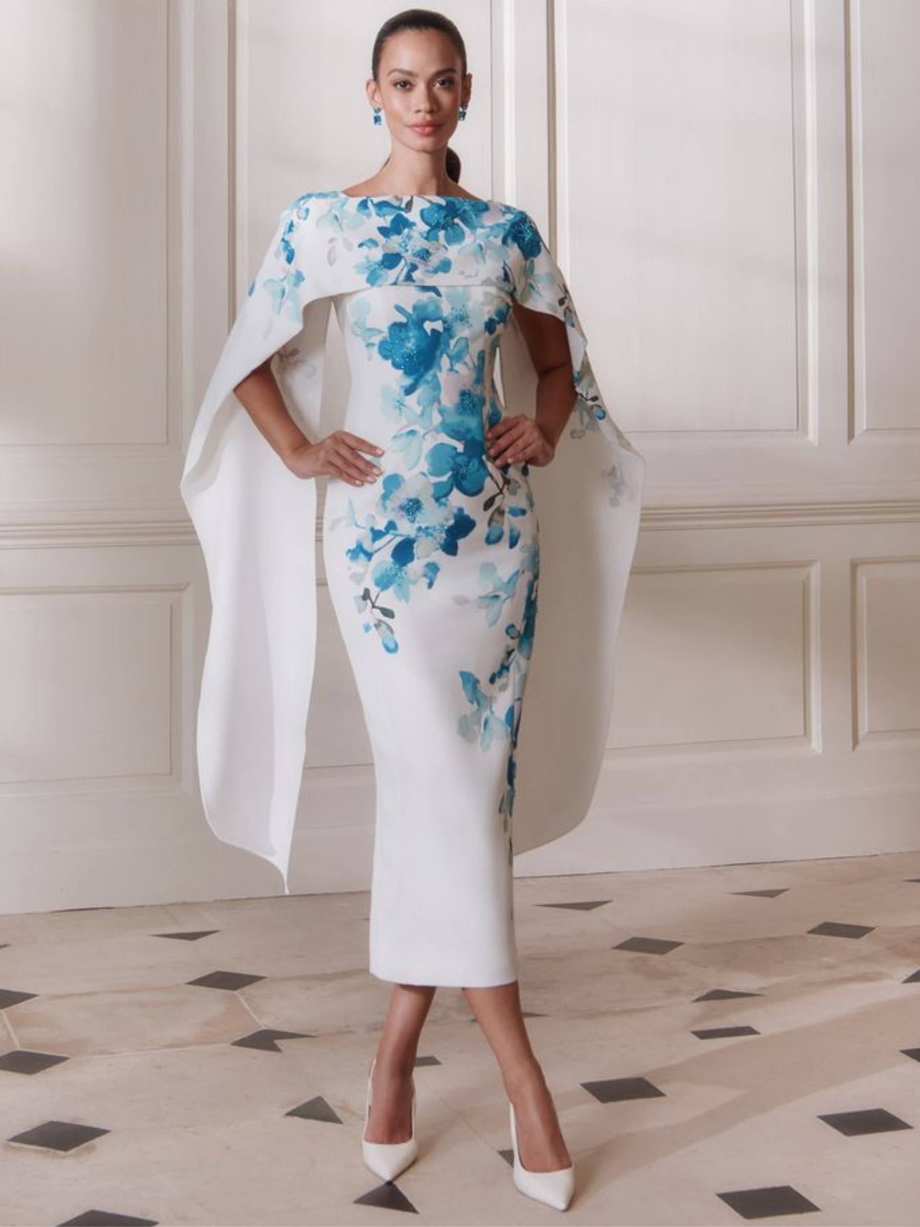 John Charles 66698 Teal Dress featuring a teal floral print, cape-style shoulder overlay and a sleek fitted silhouette — a sophisticated occasion dress perfect for weddings and elegant events.